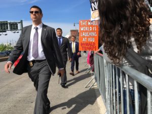 Police and Secret Service walk along the front of a designated protest zone in front of the Intrepid Sea, Air and Space Museum on May 4, 2017. More than a thousand protesters showed up to greet President Trump on his first visit to his home city of New York since becoming president. Photo Credit: James K. Galloway